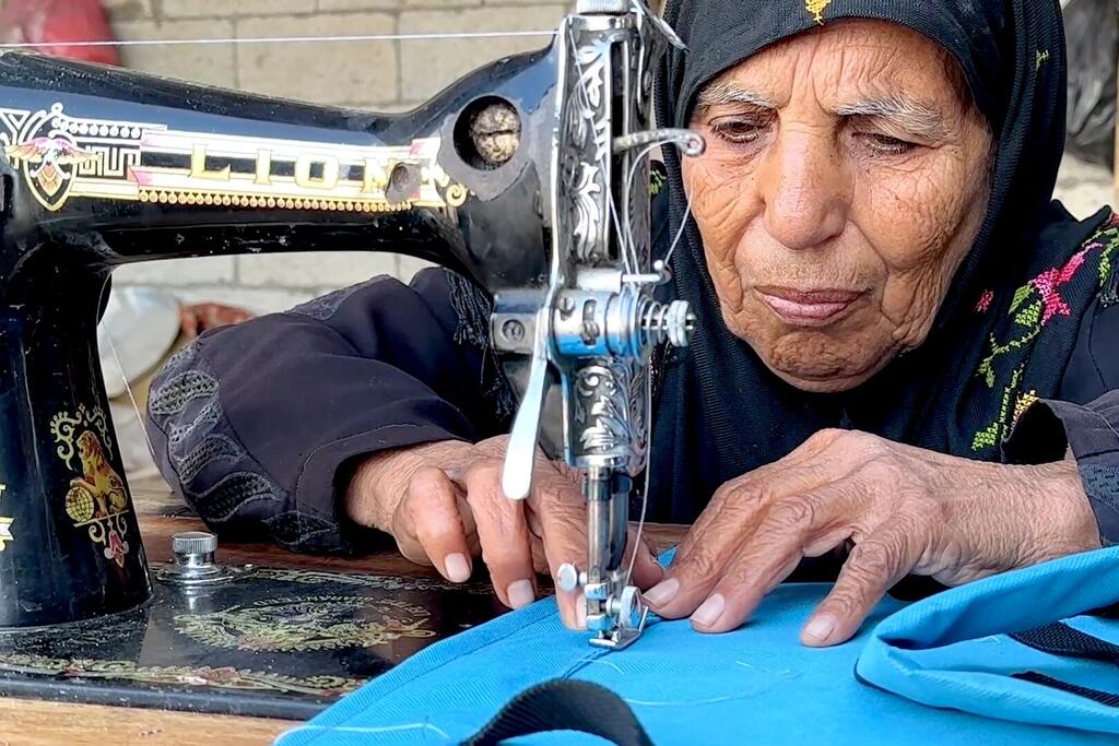 تجلس السيدة المسنة، نغين بن عيسى، خلف ماكينة خياطة بالية، وهي تحرك يديها بعناية أثناء إصلاح الملابس لعملائها. هذا العمل ليس خيارًا بل ضرورة فرضتها الحرب بعد انقطاع المساعدة الاجتماعية التي كانت أسرتها تعتمد عليها.